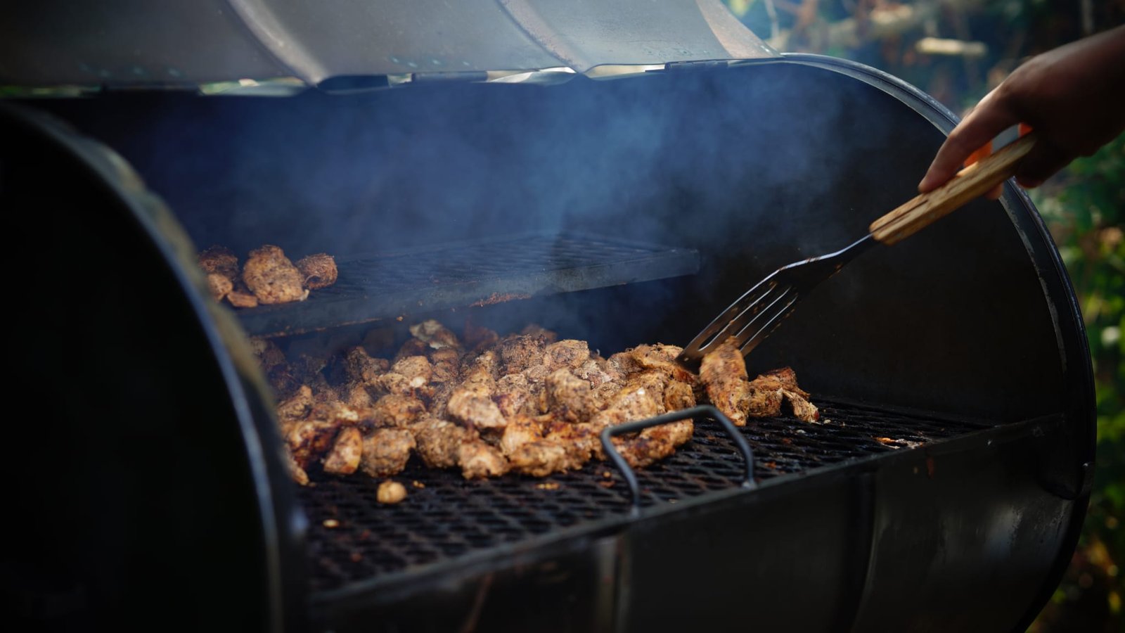 Chicken cooking over charcoal in a Grill Seekers smoker